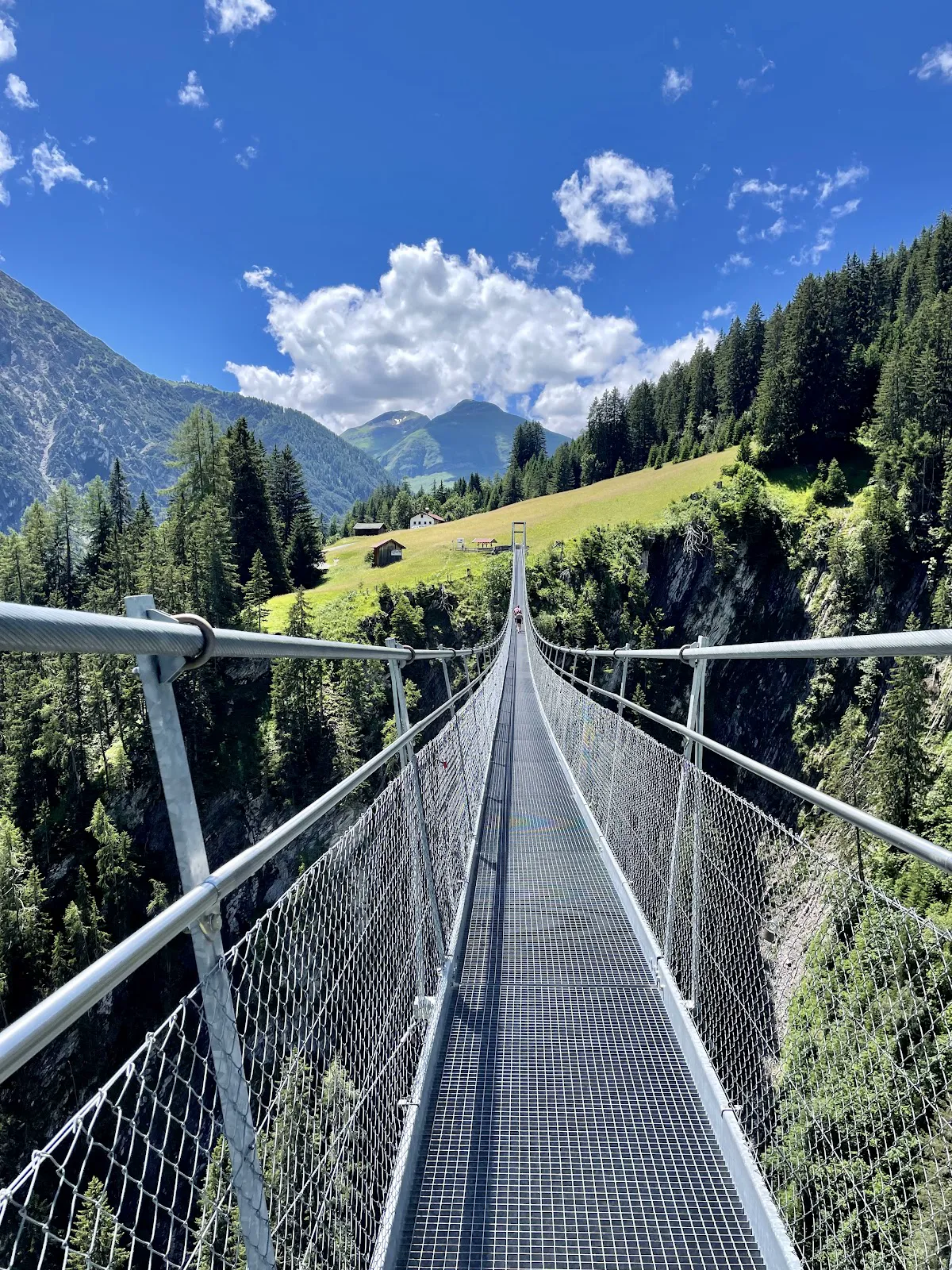 View through the steel grating floor of the Holzgau Suspension Bridge