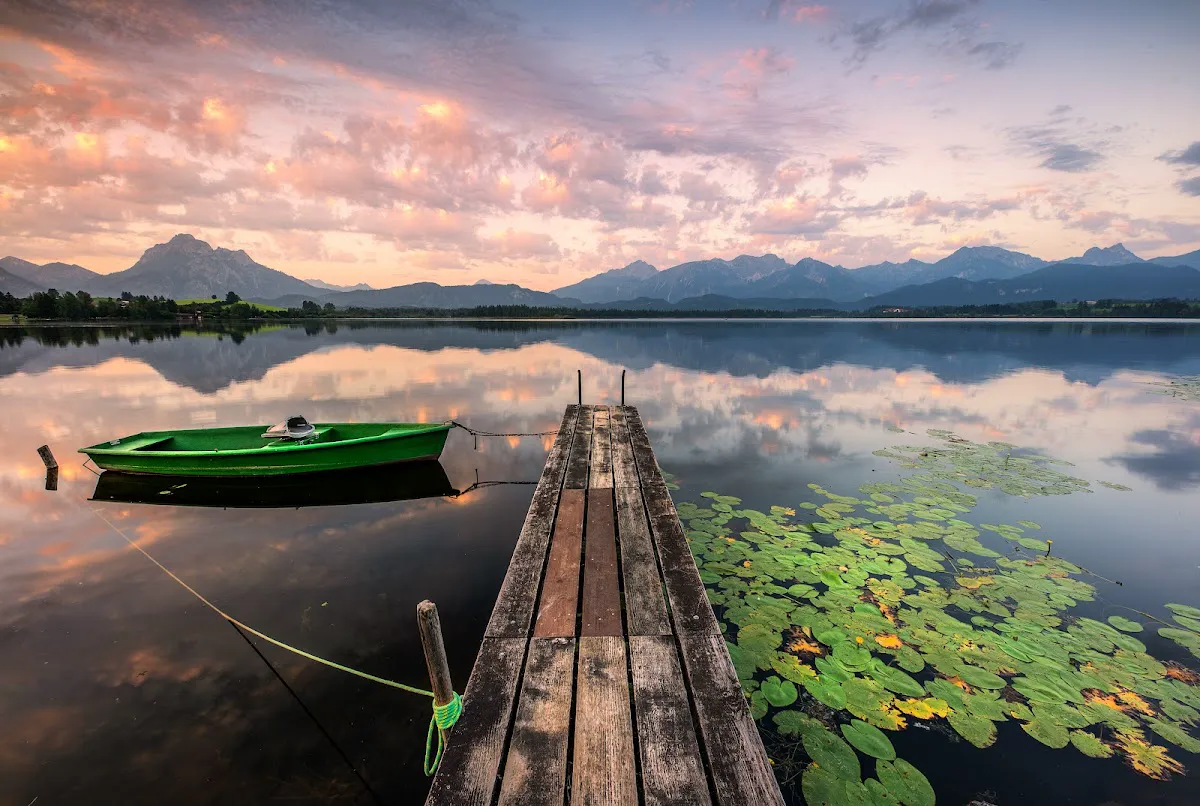 Stand Up Paddleboarder on Hopfensee with the mountains in the background