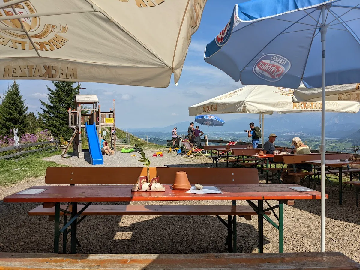 Winter hikers ascending forest road to Kappeler Alm with views of Ruine Falkenstein