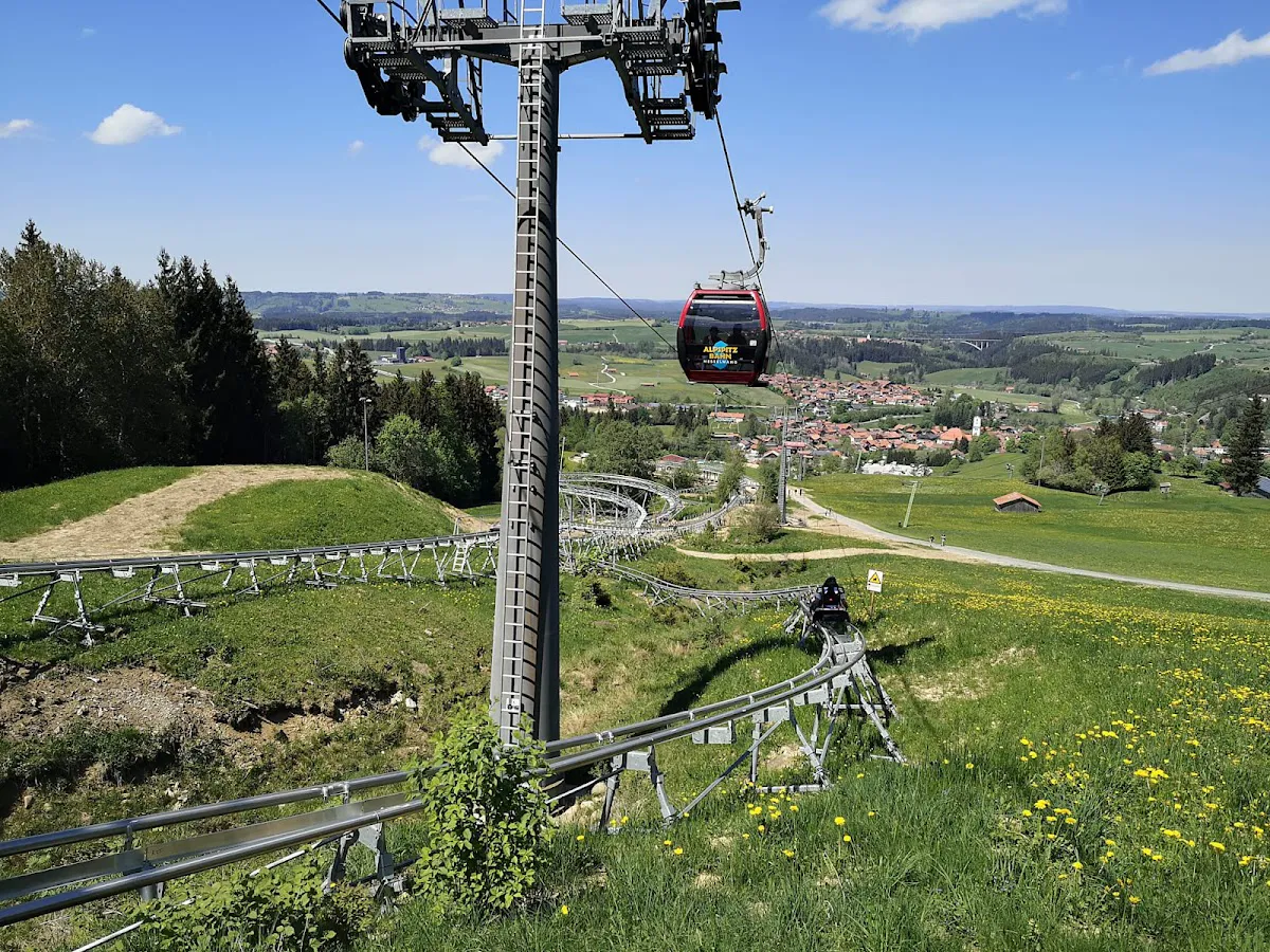 Rider banking through steep curve on Wally Blitz alpine coaster with Lechtal valley backdrop