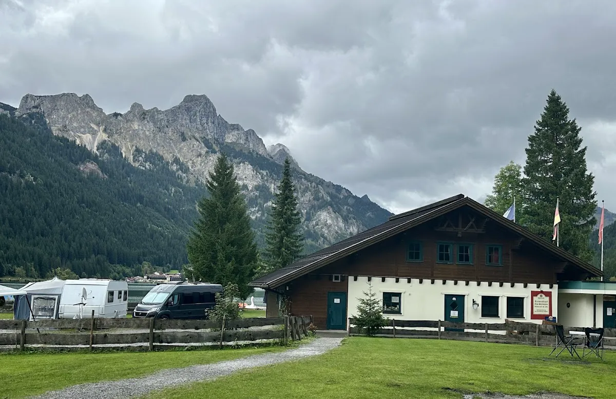 Winter ice skating on frozen Haldensee lake with mountain backdrop